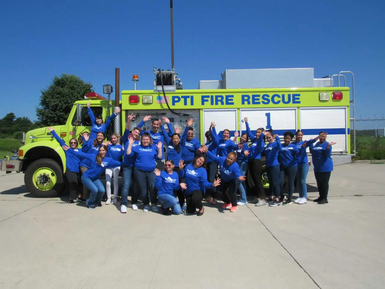 Flight attendant students posing on the fire training truck