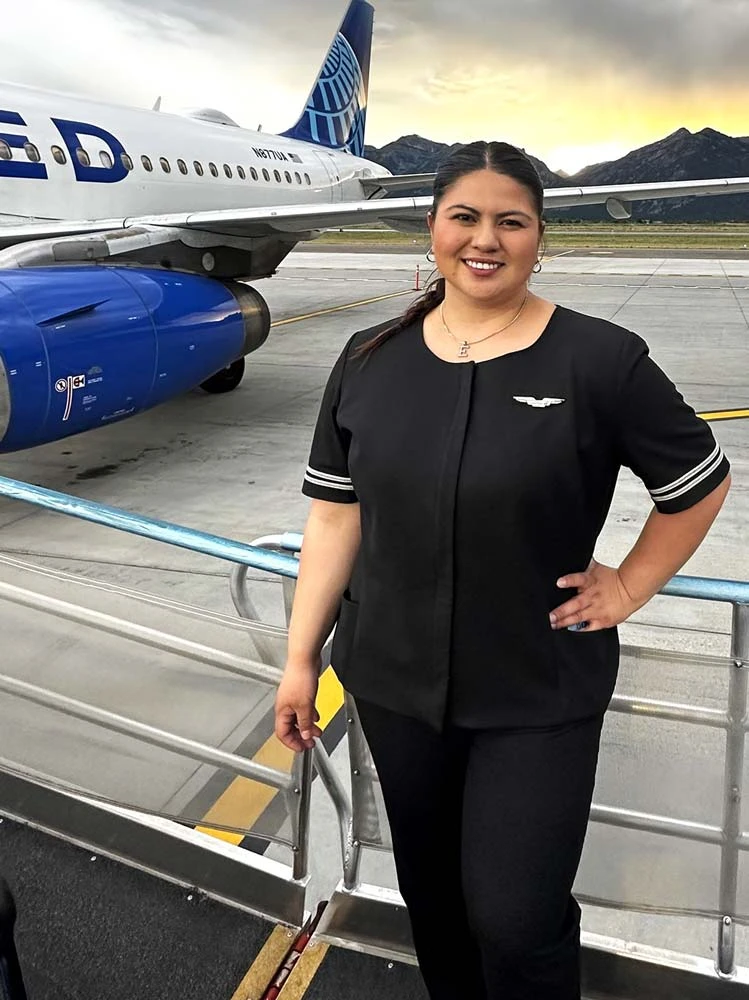 United flight attendant graduate posing in front of an aircraft