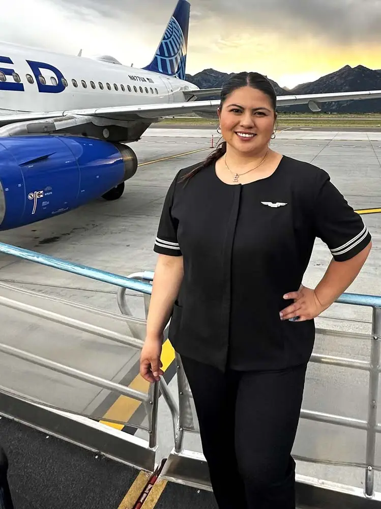 United flight attendant graduate posing in front of an aircraft