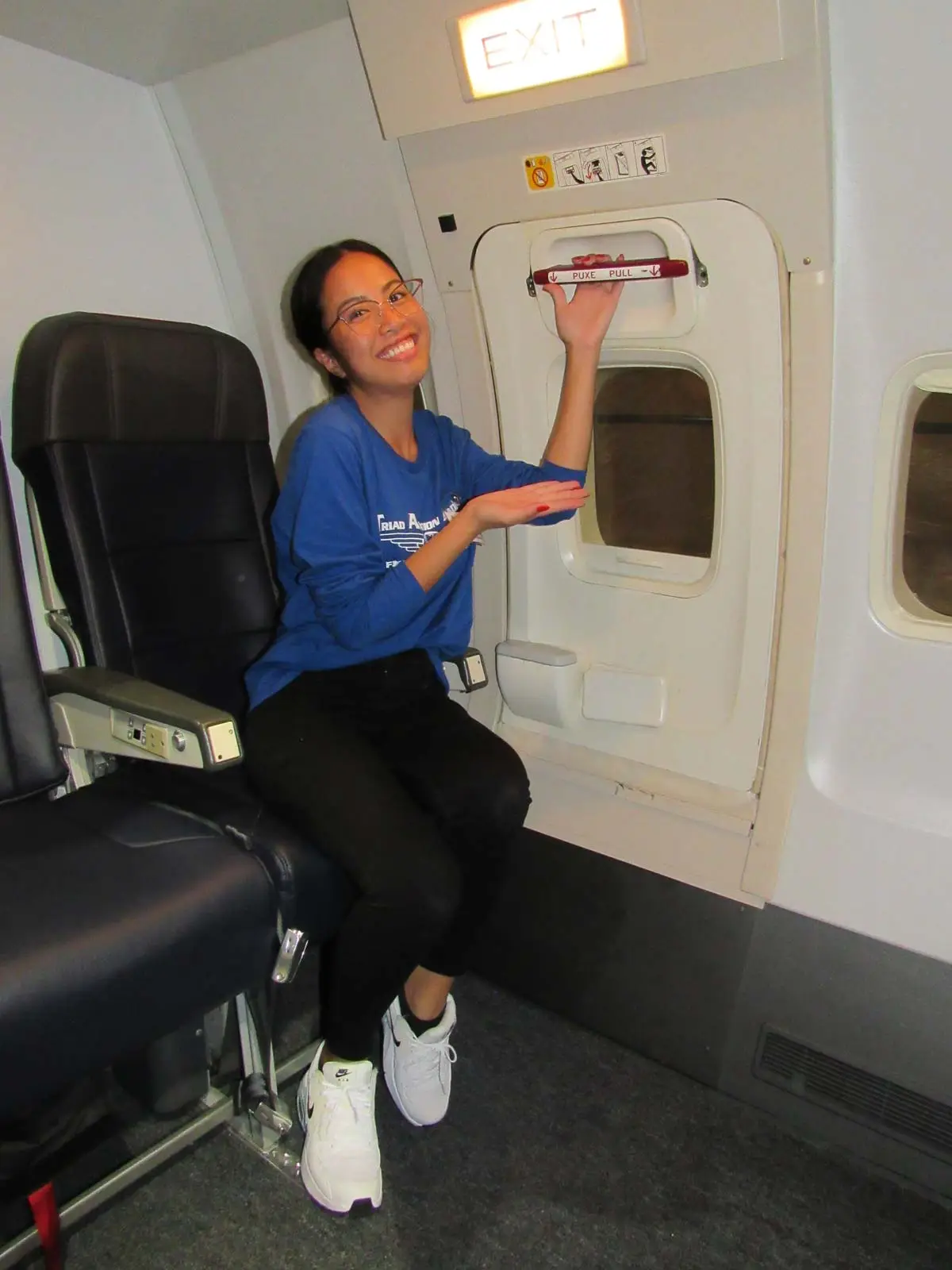 Flight attendant student practicing the aircraft door lever