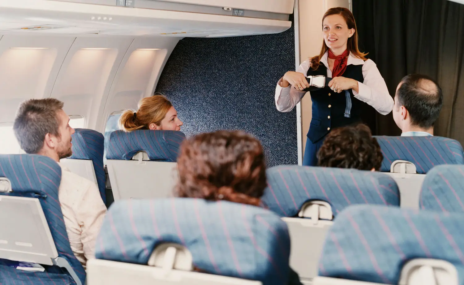 Flight attendant demonstrating in-flight safety procedures