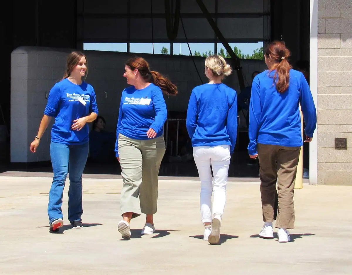 Flight attendant students walking in front of the TAA hangar