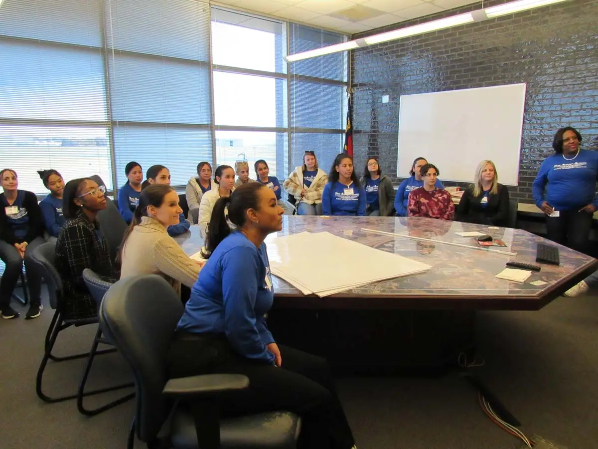Flight attendant students gathered around a table during class