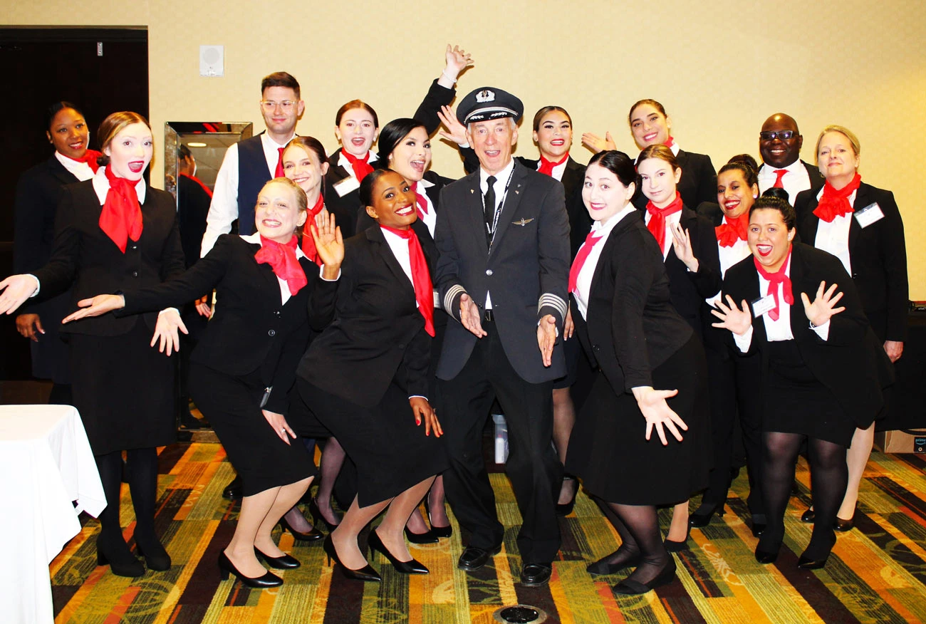 Flight attendant preparation students posing happily with their instructor