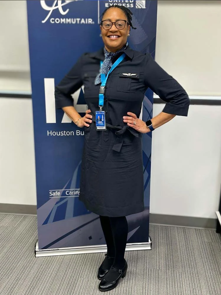 Flight attendant student posing in front of an airline banner