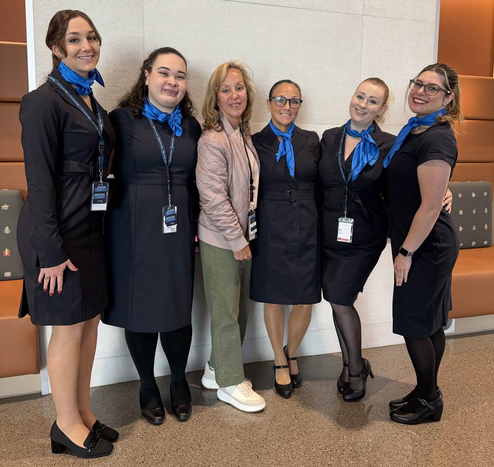 Triad Aviation Academy instructor posing with a group of recent flight attendant graduates
